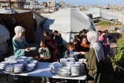 As irmãs palestinas Lina Zeid (à esquerda) e Aya Zeid distribuem pacotes de alimentos para crianças deslocadas em Gaza