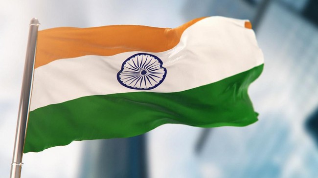 National Flag of India Against Defocused City Buildings